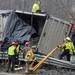 Rescue crews work to secure chains to a turned over trailer as they prepare to lift it upright using two tow trucks. The trailer flipped onto its side, spilling part of its load and pinning another vehicle against the guardrails on south U.S. 23 north of Six Mile Road in Northfield Township on Monday, March 11, 2013. Melanie Maxwell I AnnArbor.com